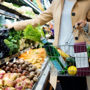 Woman at grocery store with hand-held cart